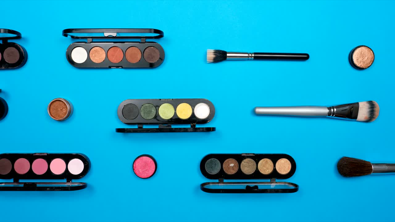Cosmetics set for women on blue paper background,top view stop motion animation timelapse