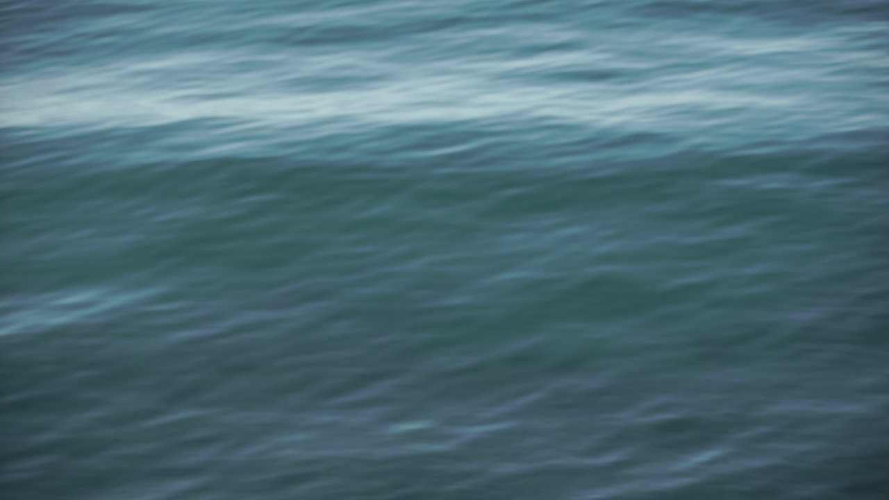 Calm blue turquoise sea, waves rolling gently in