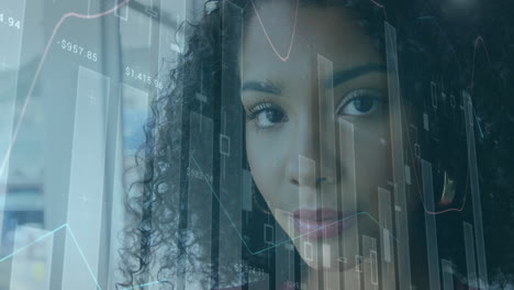 animación de múltiples gráficos y números sobre el retrato de una mujer de negocios biracial sonriente en la oficina.