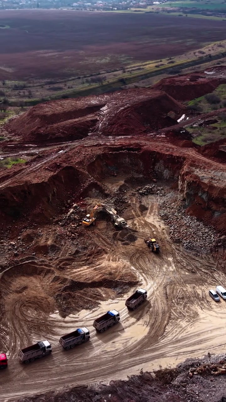 Aerial View of Heavy Machinery and Trucks Working in an Open Pit Quarry