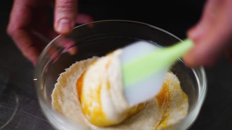 Fixed-shot-showing-chef-gently-stirring-and-mixing-dessert-to-fold-in-fruit-puree,-in-small-glass-bowl