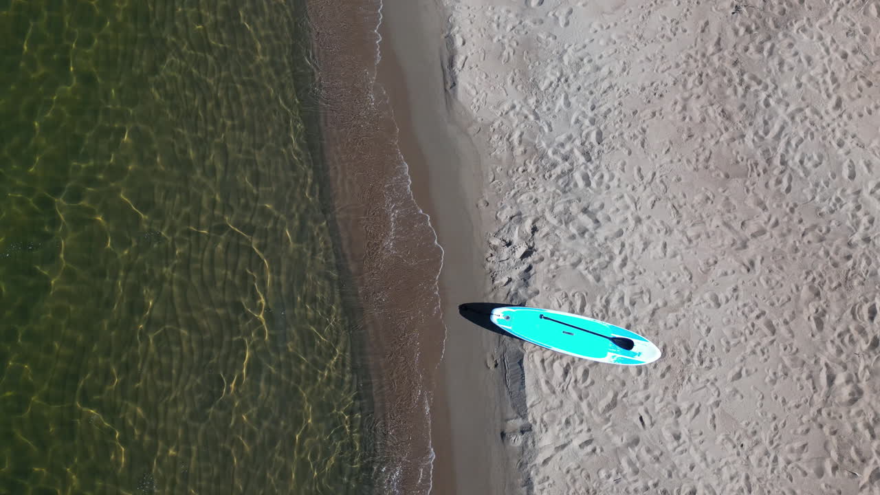 sup board paddleboard en una playa soleada junto al océano, bulgaria, vista aérea de arriba hacia abajo