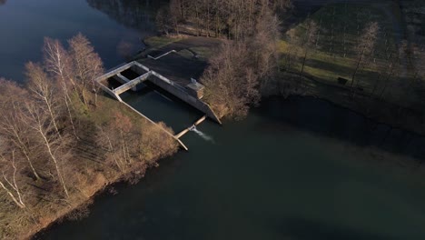 Static-aerial-view-of-fresh-water-entering-a-natural-reservoir-at-sunset-in-Germany