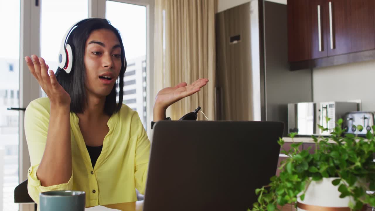 persona de género fluido de raza mixta grabando un podcast usando una computadora portátil en casa