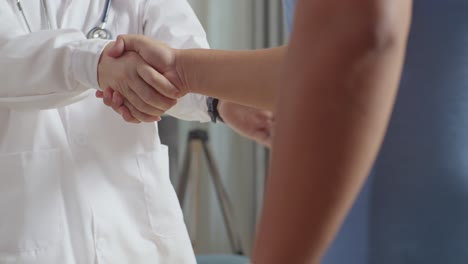 primer plano de un médico asiático se encuentra con un paciente gordo en la clínica, entra a la clínica, se da la mano, se sienta y discute sobre el chequeo médico