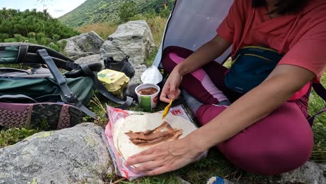 woman hiking in the mountains and having a snack