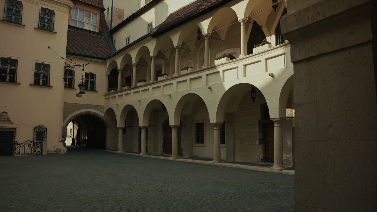 Soft light fills a historic courtyard with arches, muted tones, and quiet elegance