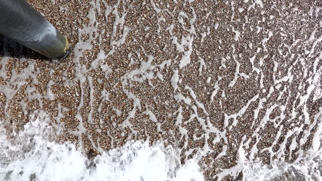 Onde su una spiaggia sabbiosa con una pipa