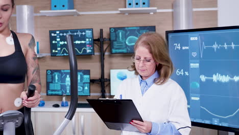 Female-doctor-in-sport-science-taking-notes-on-her-clipboard