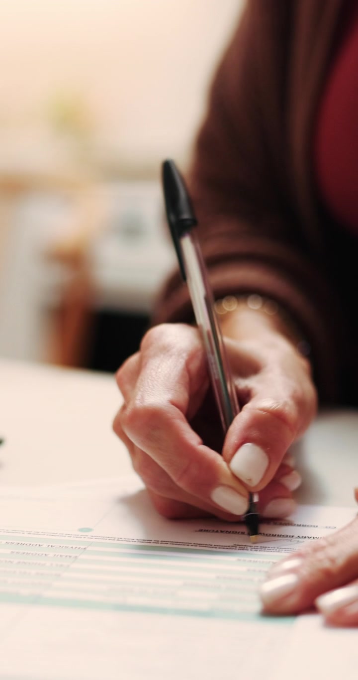 Primo piano di una donna che firma un documento legale
