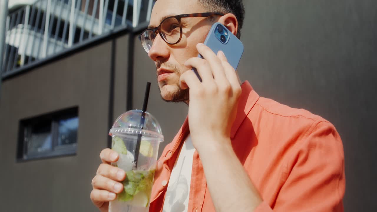 hombre hablando por teléfono y bebiendo
