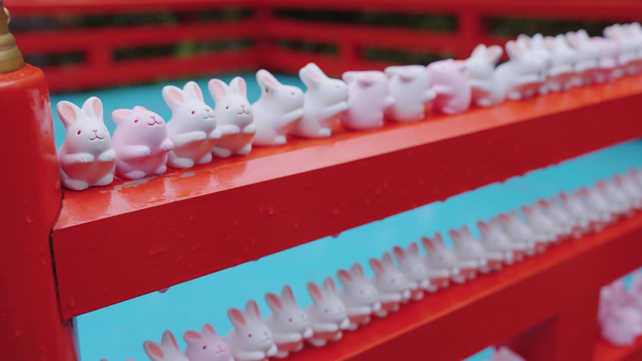 сотни маленьких статуэток кроликов в окидзаки-дзиндзя в киото (япония)