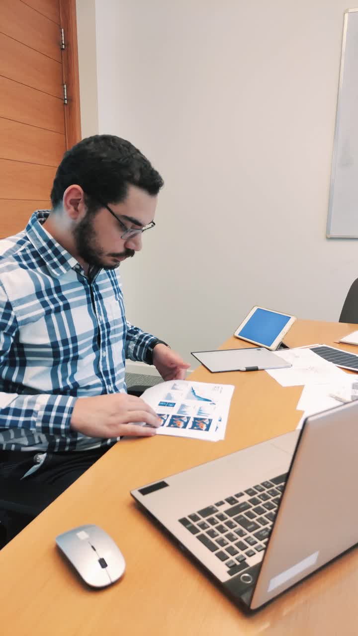 Male Engineer Reviewing a Technical Report in His Office