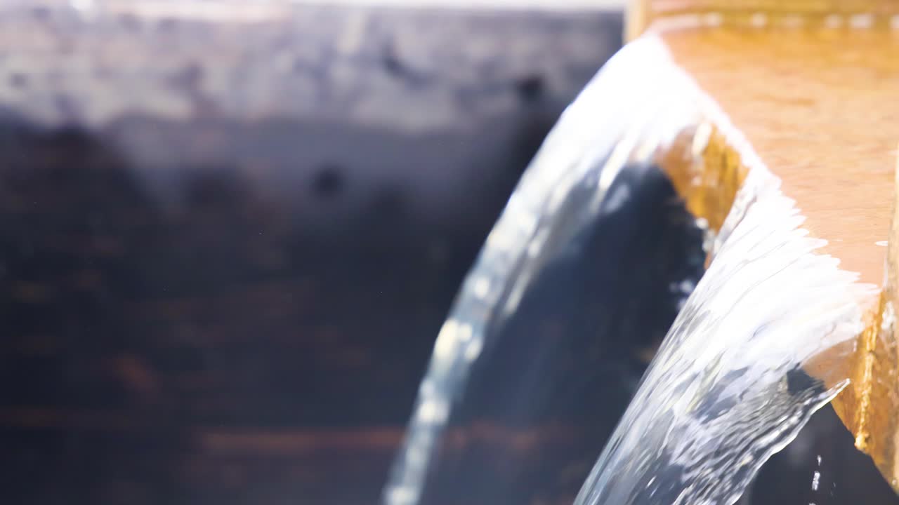Water flows over a wooden dam structure