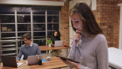mujer de negocios creativa que usa una mesa digital en una oficina moderna