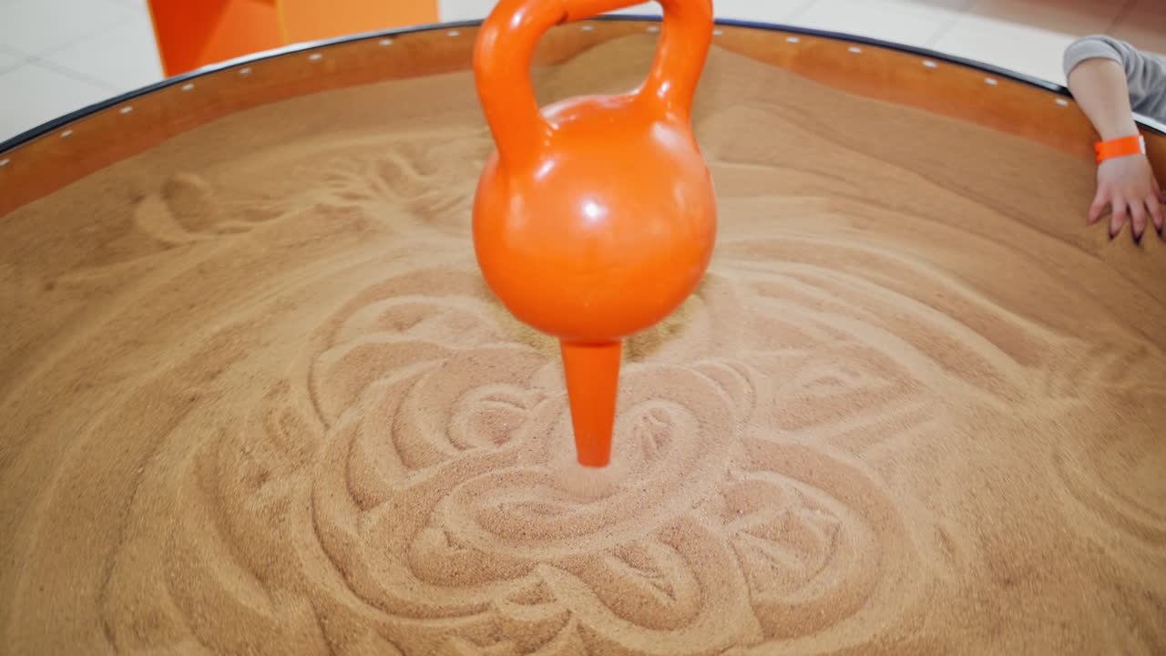 The pendulum draws on the sand. Science exhibition museum.