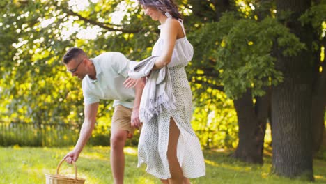 Glückliches-Paar-Legt-Picknickdecke-Im-Sommerpark.-Freizeit,-Urlaub-Und-Menschen-Konzept-Glückliches-Paar-Legt-Picknickdecke-Im-Sommerpark