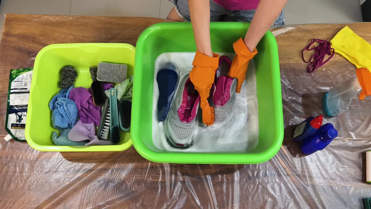 Cleaning shoes with brush in soapy water
