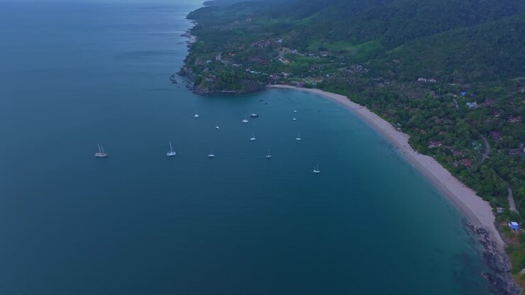 Filmato aereo di una barca che naviga oltre scogliere suggestive a Koh Lanta, Thailandia