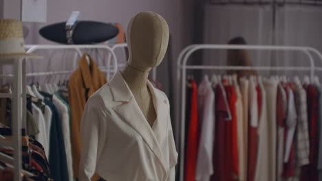 Attractive-woman-smiling-to-the-camera-while-trying-on-a-new-dress-at-the-store.-Beautiful-female-customer-standing-in-front-of-the-mirror-in-a-dressing-room