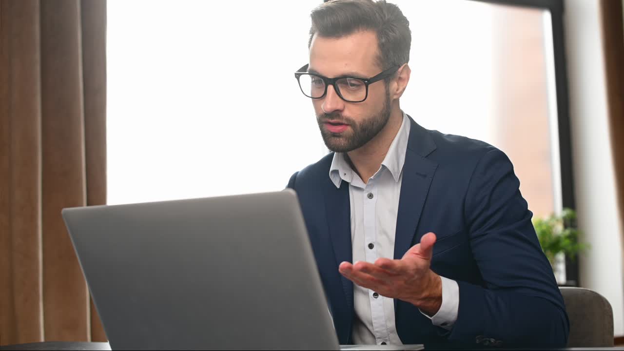 Apuesto empresario usando una laptop para una videollamada