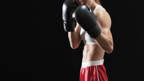 young caucasian woman boxer in boxing gear, with copy space on a black background