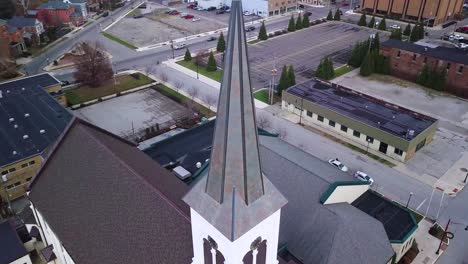 aerial view rising up quaint logansport church steeple, cross and bell tower, indiana