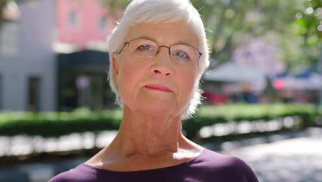 serious old woman with glasses outside