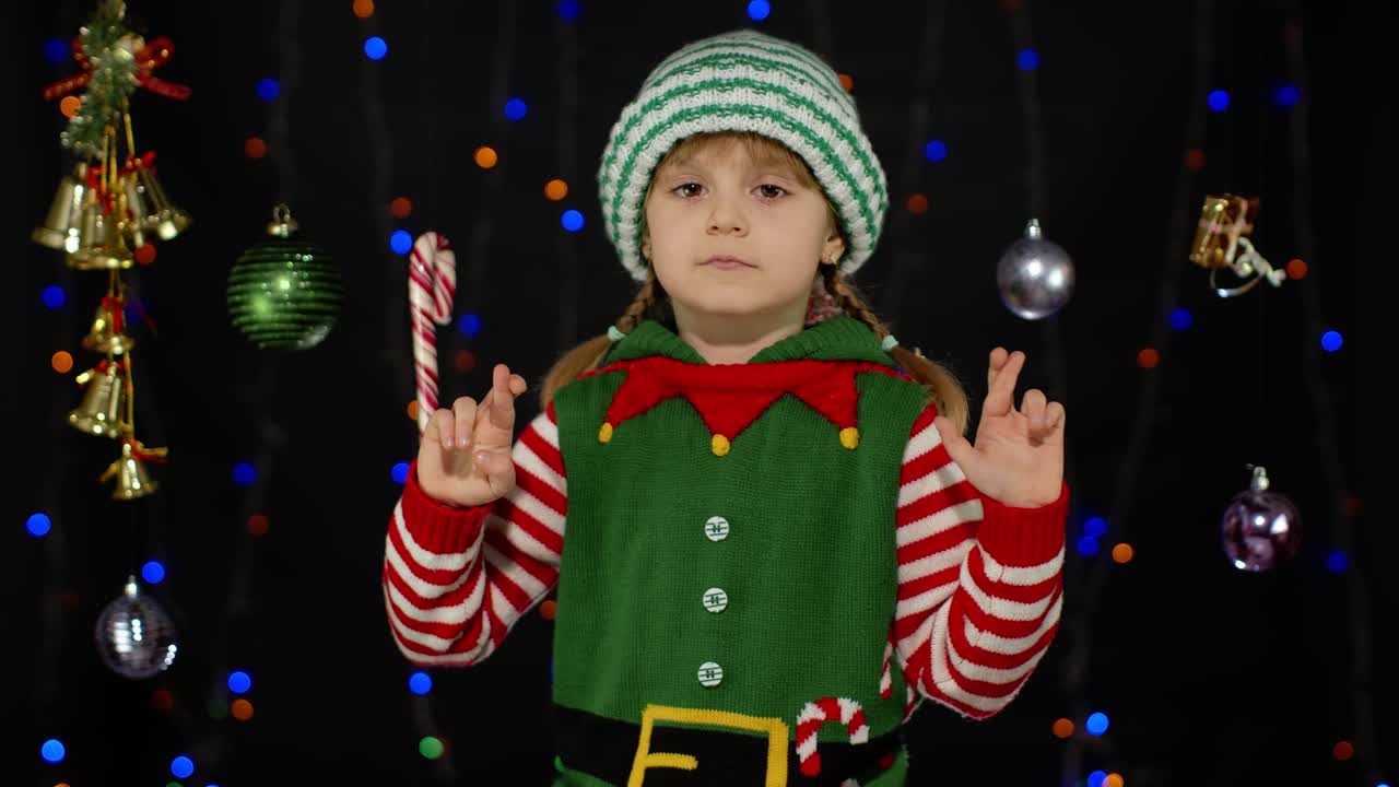 Christmas wish concept. Kid teen girl in Christmas elf Santa helper costume making a wish, prays