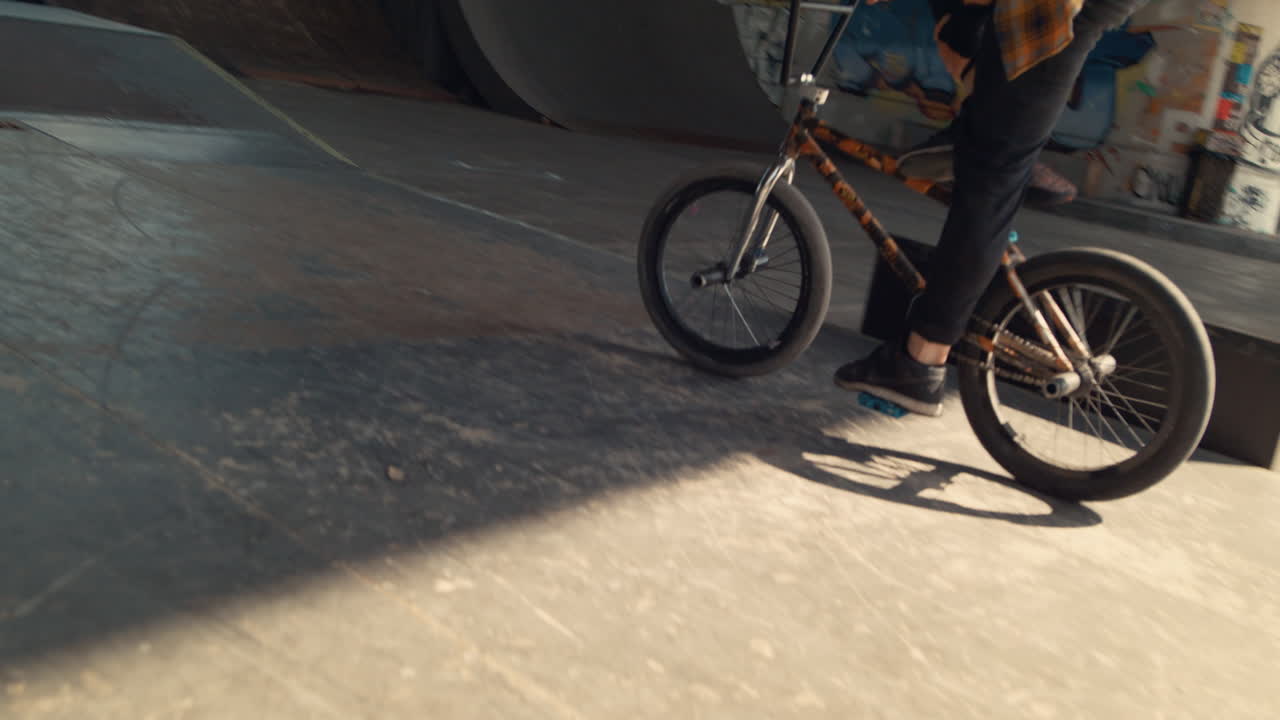 스포츠 바이커가 도시 스케이트 파크에서 bmx 자전거에서 트릭을 수행합니다.