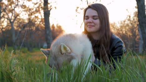 young girl playing and running with siberian husky in the park, slow motion