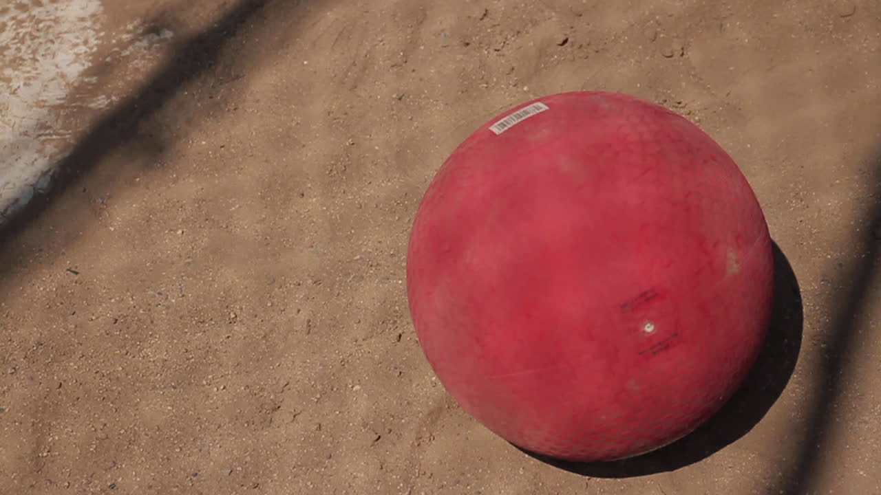 Red ball on ground and sneakers
