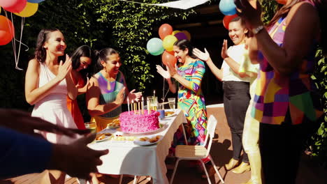 joyful outdoor birthday celebration with cake and balloons