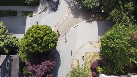 vista aérea de pájaro de 1-3bev 200 pies sobre viviendas unifamiliares de poca altura, apartamentos, comunidad residencial tranquila y tiendas minoristas sin apenas gente caminando de compras en un día soleado con árboles frondosos