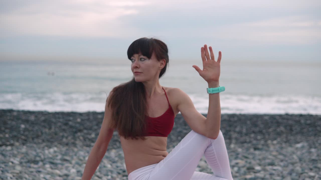 mujer practicando yoga en la playa