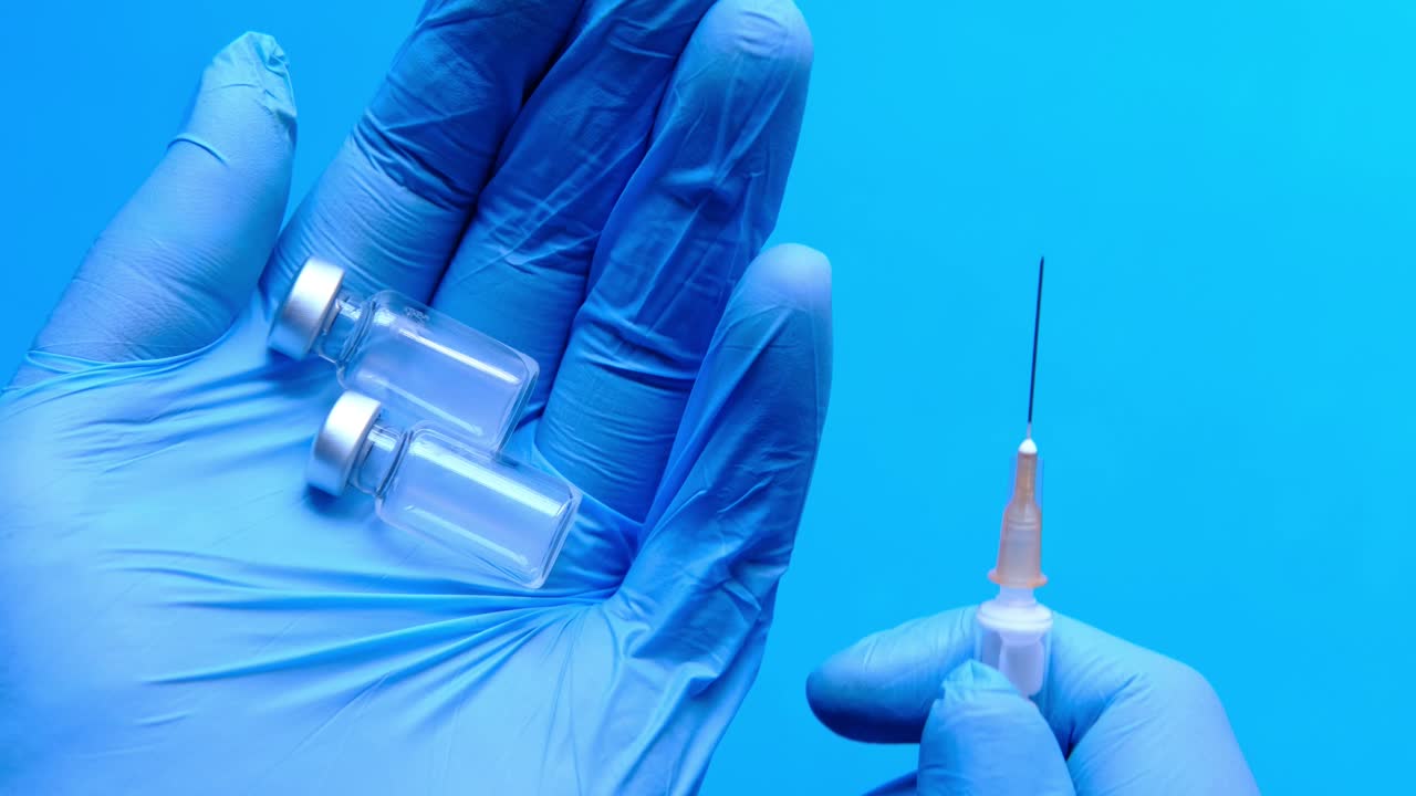 백신 병과 주사기를 가진 의학적 손