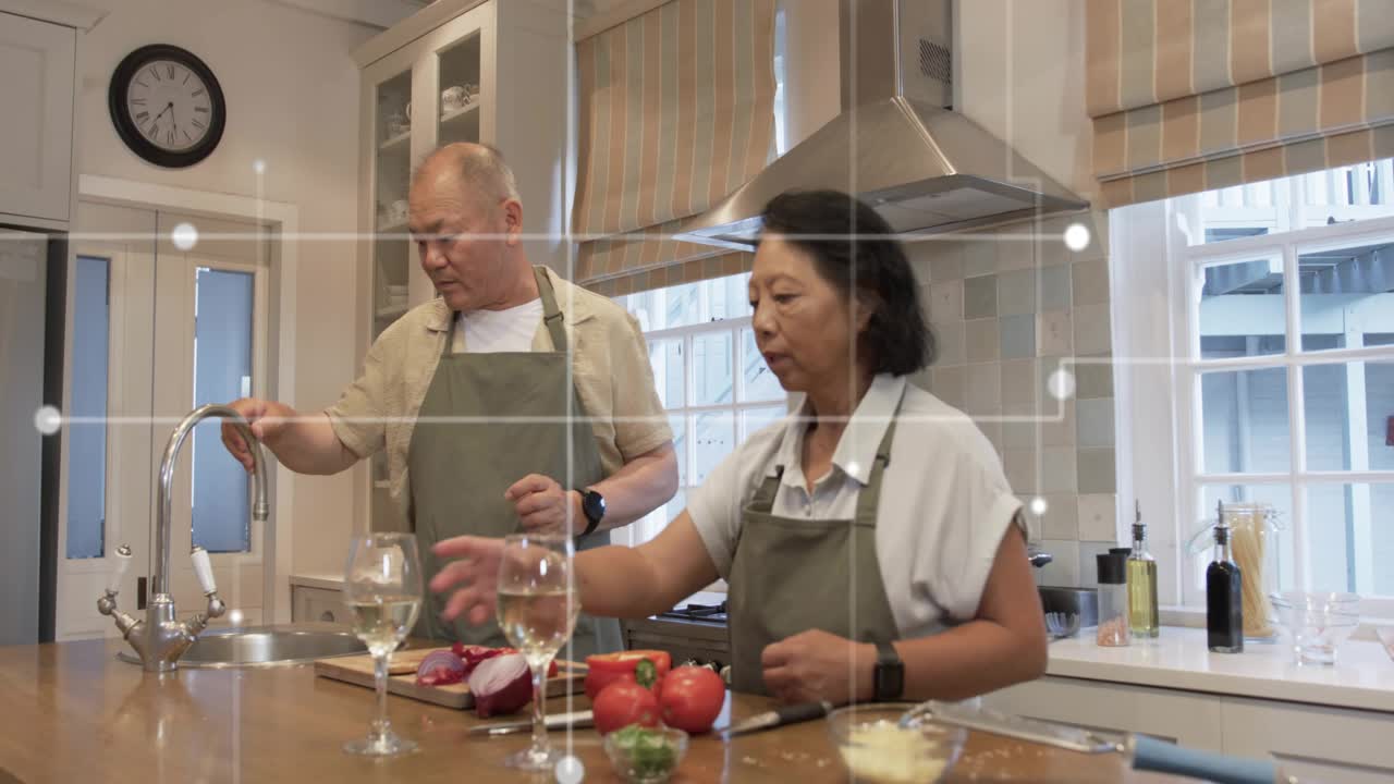 Mature man draining pot into sink, moving pot to stove, stirring while senior woman prepping meal