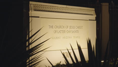 sign of lds church mormon temple at night that says "the church of jesus christ of latter-day saints gilbert arizona temple