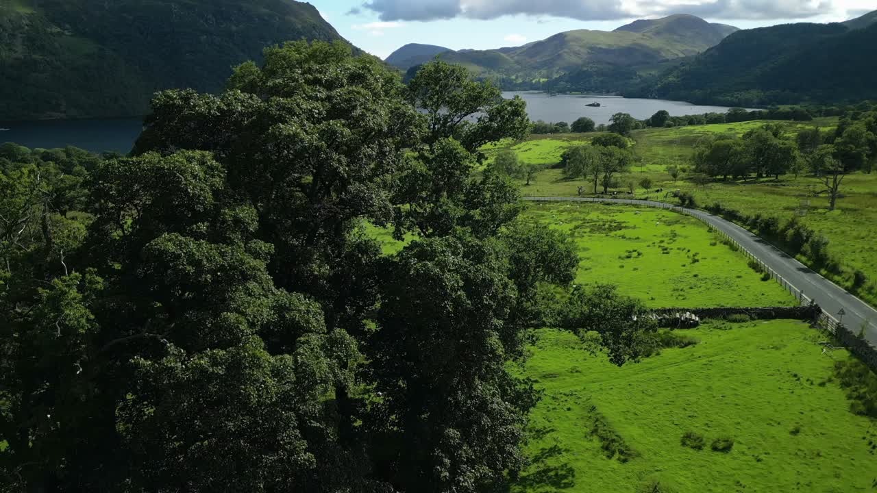 밝은 여름 날에 바쁜 도로 a5091과 함께 가파른 숲이 우거진 산으로 둘러싸인 푸른 시골과 어두운 호수의 공개