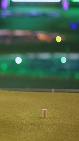a golfer practices swing at driving range