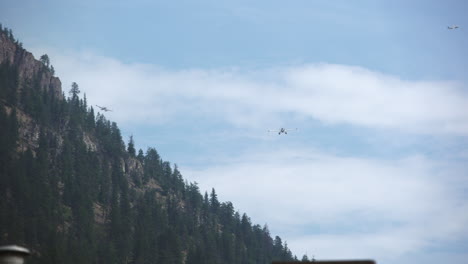 Float-airplanes-flying-in-sky-near-mountain,-seaplane-landing-approach