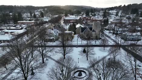 Aerial-rising-shot-of-snow-falling-on-beautiful-small-town-in-America,-Wellsboro,-PA