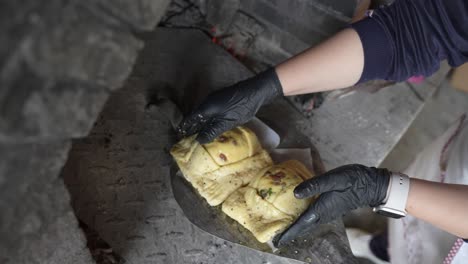 flaouna siendo colocado en un viejo horno de piedra tradicional para hornear