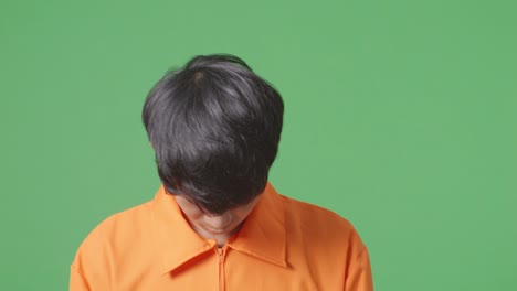 녹색 화면 배경에서 걸어다니는 수갑에 인 아시아 남성 수감자의 클로즈업