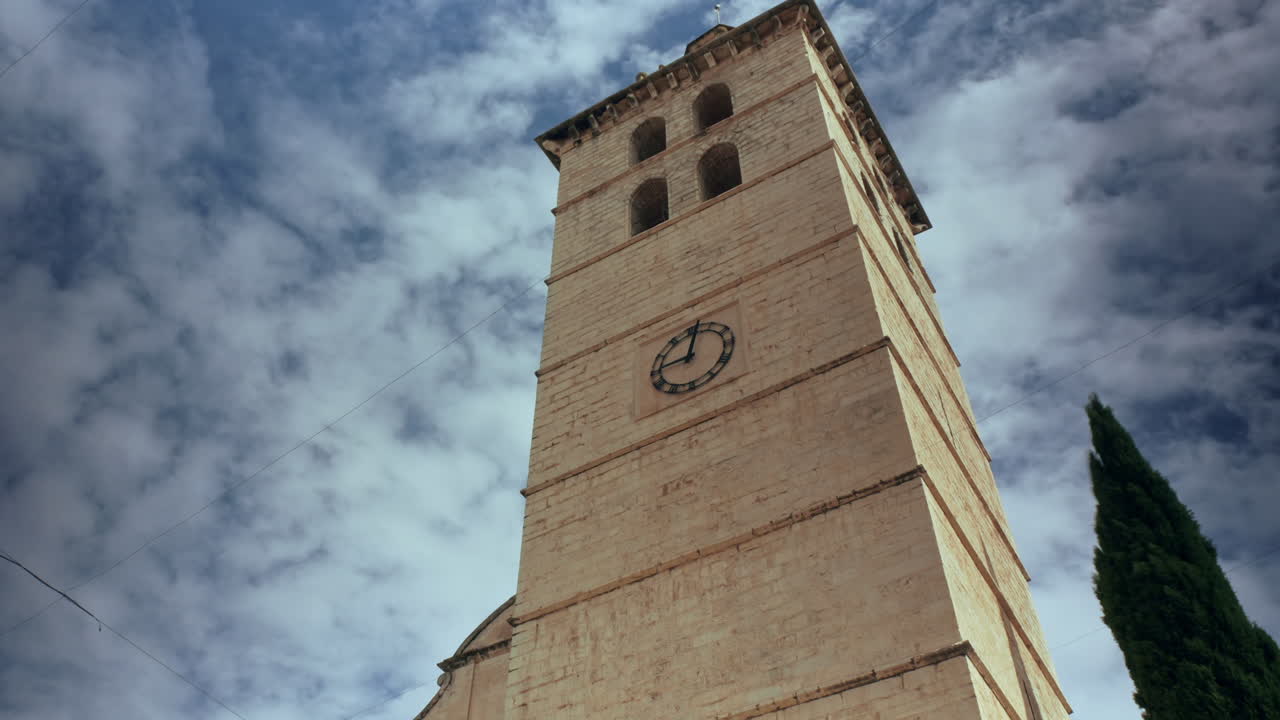 Questo timelapse cattura l'antica torre della chiesa di Inca a Maiorca contro un cielo blu mentre le nuvole passano