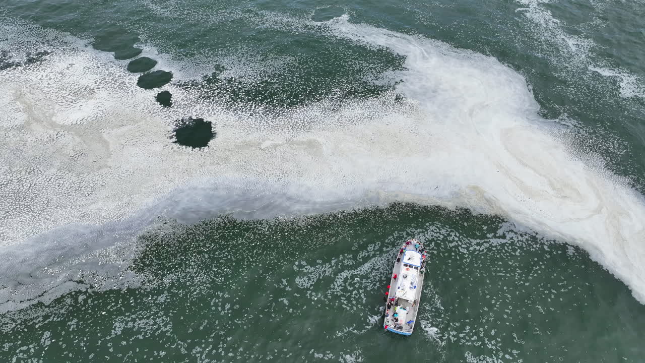 High angle drone shot of a whale safari boat at the sea in cloudy Oregon, USA