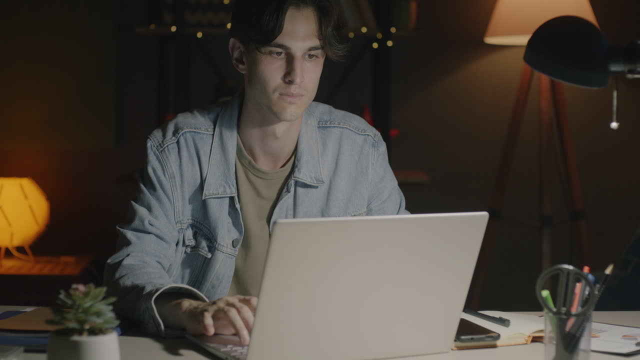 Young Man Working Late at Night on Laptop