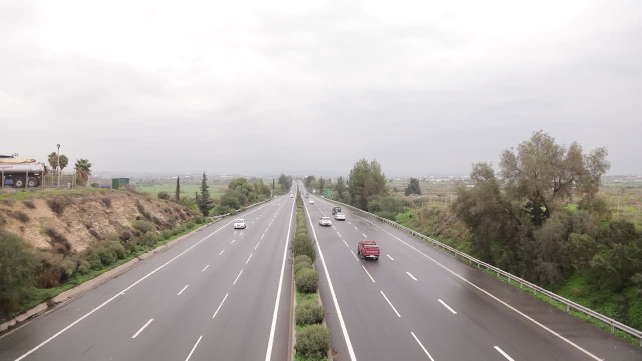Upper wide shot of a national highway with cars driving by.