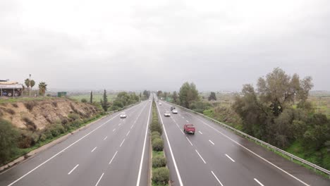 upper wide shot of a national highway with cars driving by.