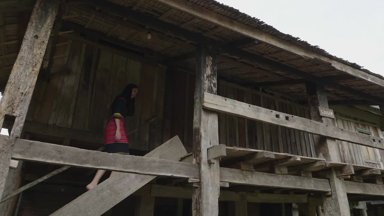 Woman walking up the stairs of an old wooden house